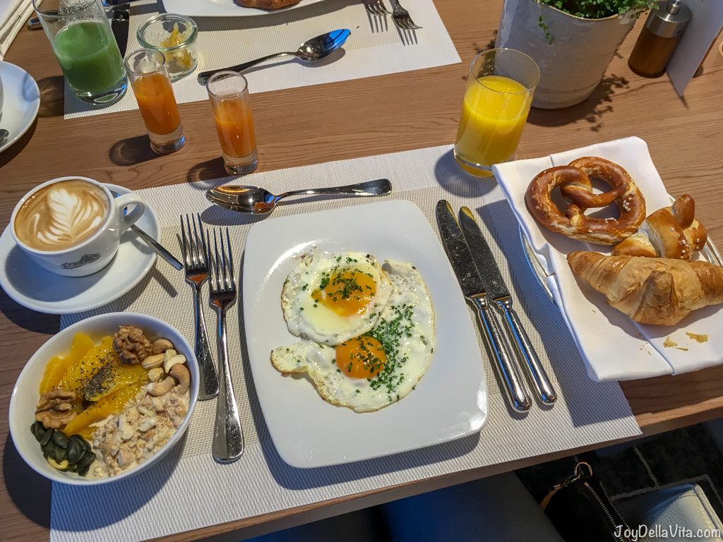 My Kempinski Berchtesgaden Breakfast with fried eggs, juice, cappuccino and fresh orange slices with bircher muesli