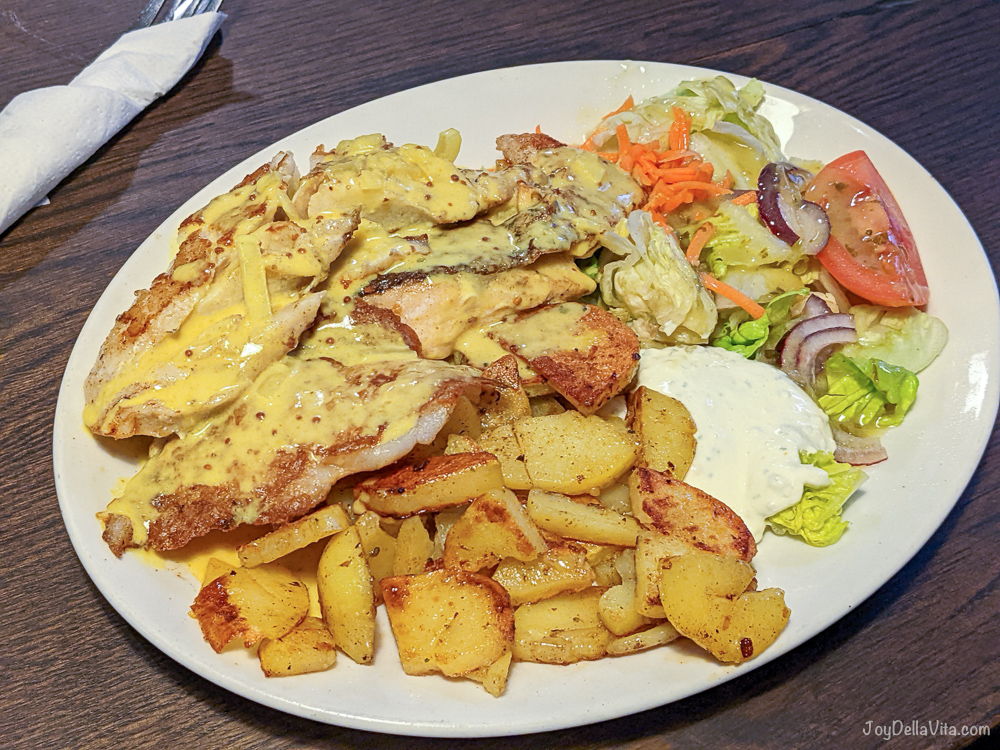 mixed fish with fried potatos and mustard sauce and salad in a restaurant in hamburg